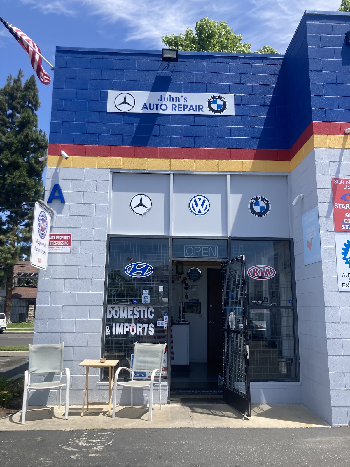 Front entrance of John's Auto Repair with manufacturer badges